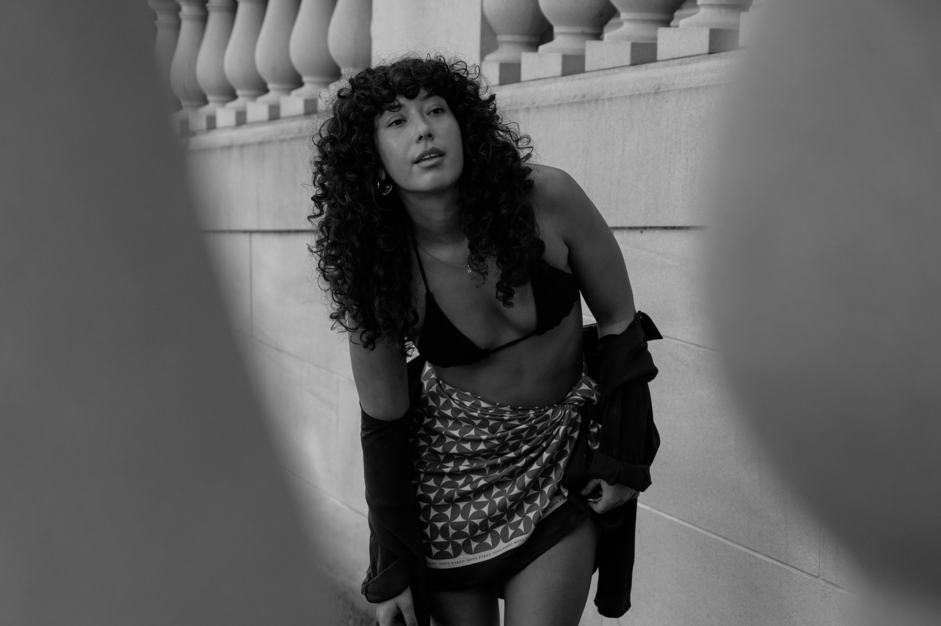 Person leaning against a decorative wall with a black and white filter