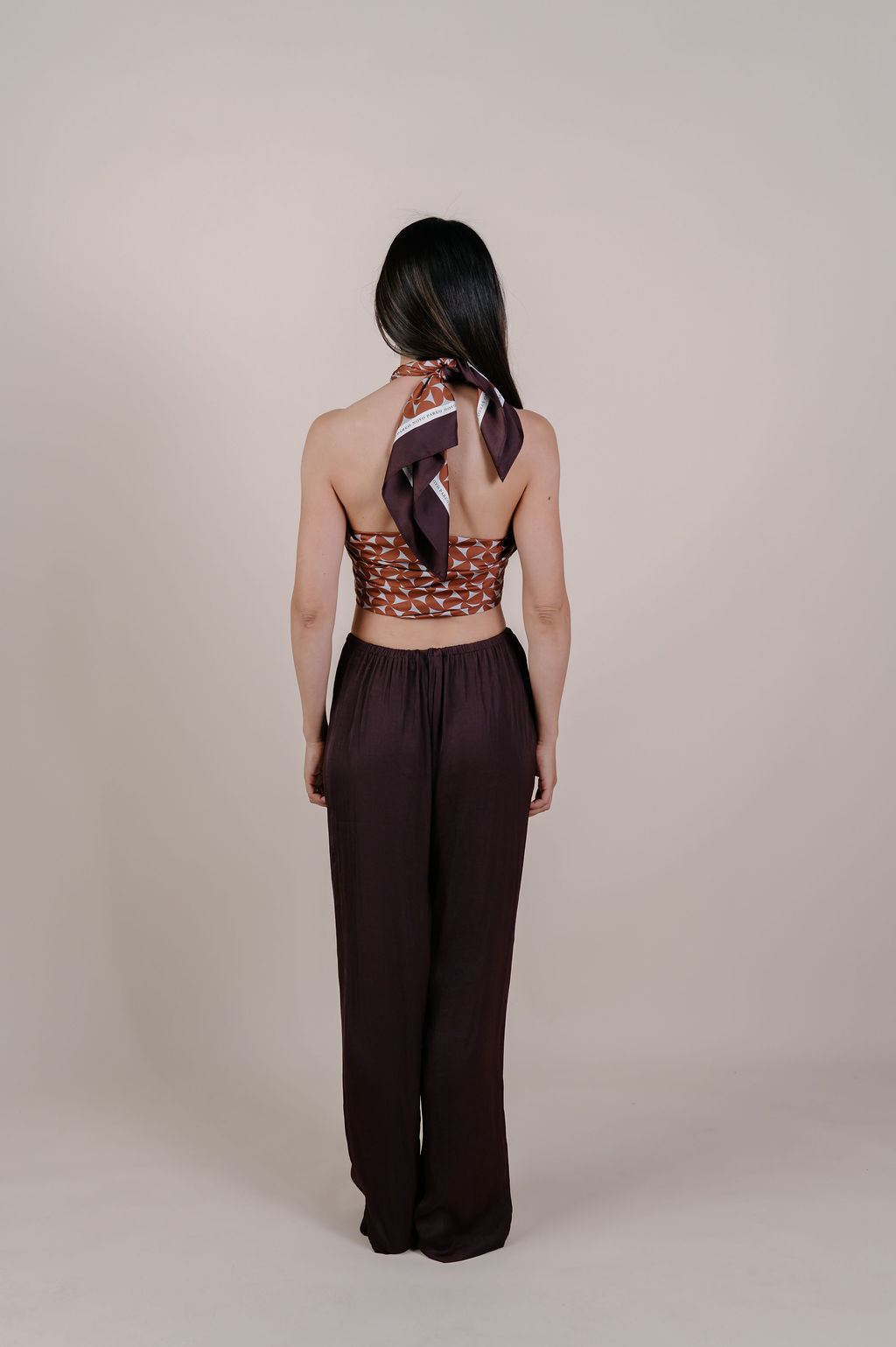 Model wearing the Celine caramel geometric silk pareo by Novo Pareo. 100% Mulberry Silk Twill with a rich caramel and ivory pattern, reflecting timeless elegance and Australian refined resort wear.