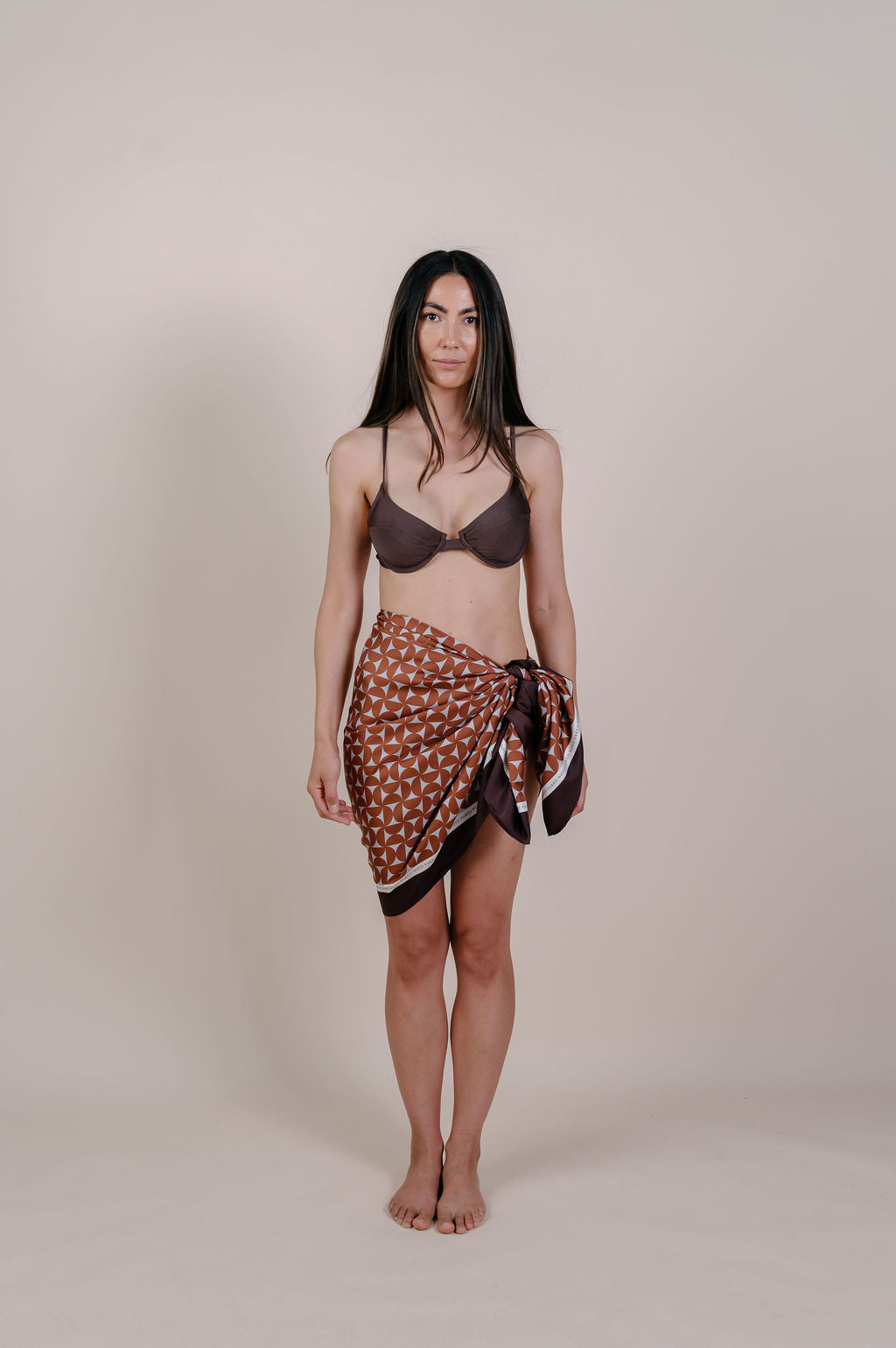 Model wearing the Celine caramel geometric silk pareo by Novo Pareo. 100% Mulberry Silk Twill with a rich caramel and ivory pattern, reflecting timeless elegance and Australian refined resort wear.