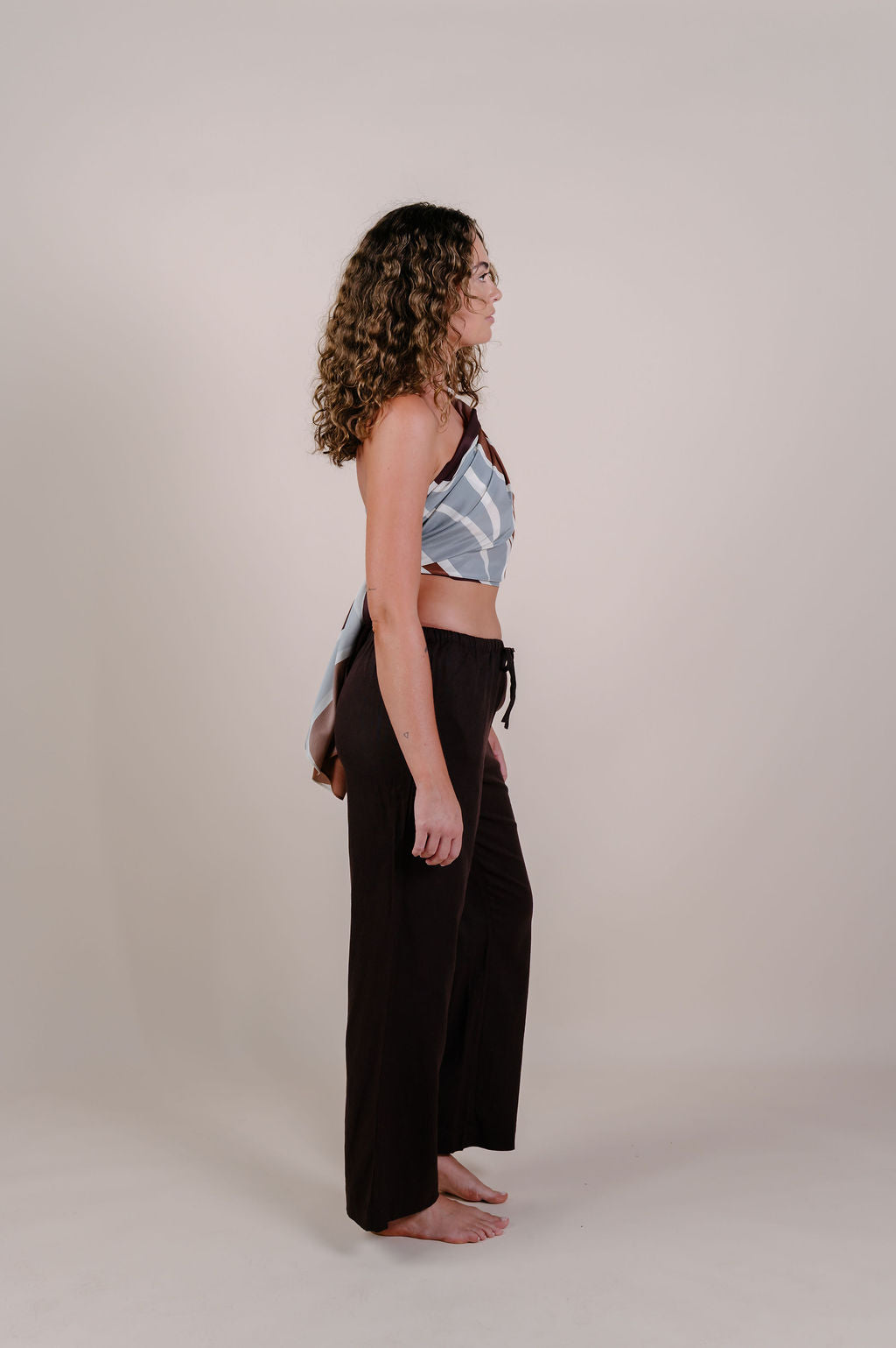 Model wearing the Isla flow print silk pareo by Novo Pareo. Elegant abstract design in deep chocolate and soft grey, crafted from 100% Mulberry Silk Twill for effortless, versatile resort wear.