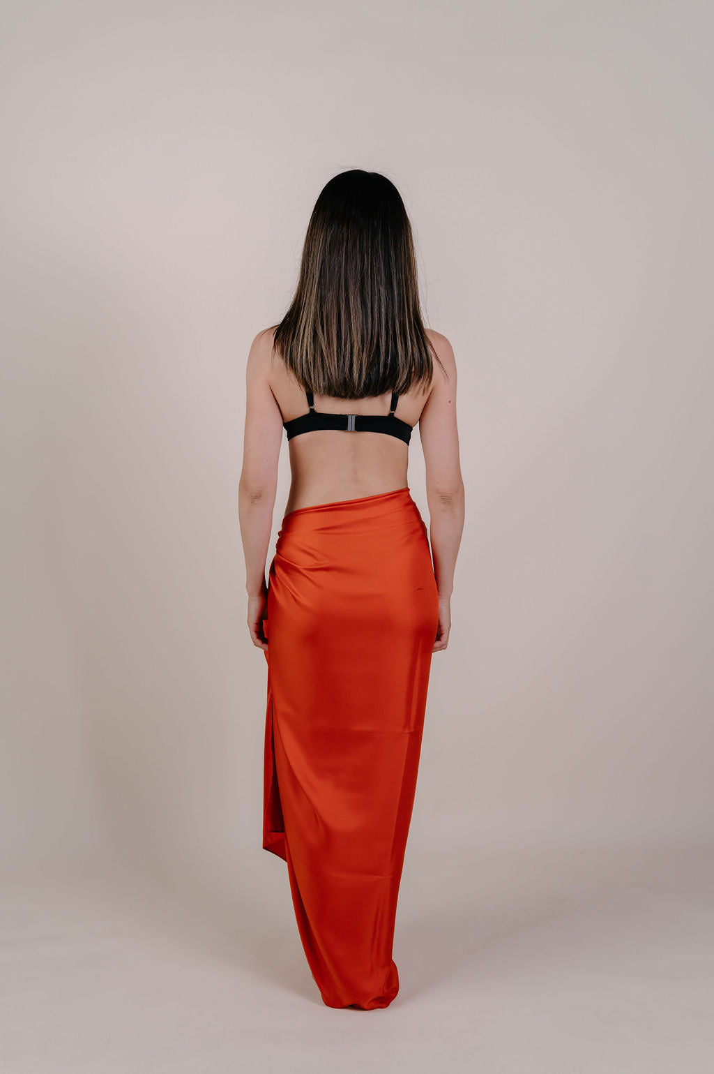 Model wearing the Luana solid terracotta silk pareo by Novo Pareo. Made from 100% Mulberry Silk Twill in warm terracotta, a timeless and versatile piece for refined Australian resort wear.