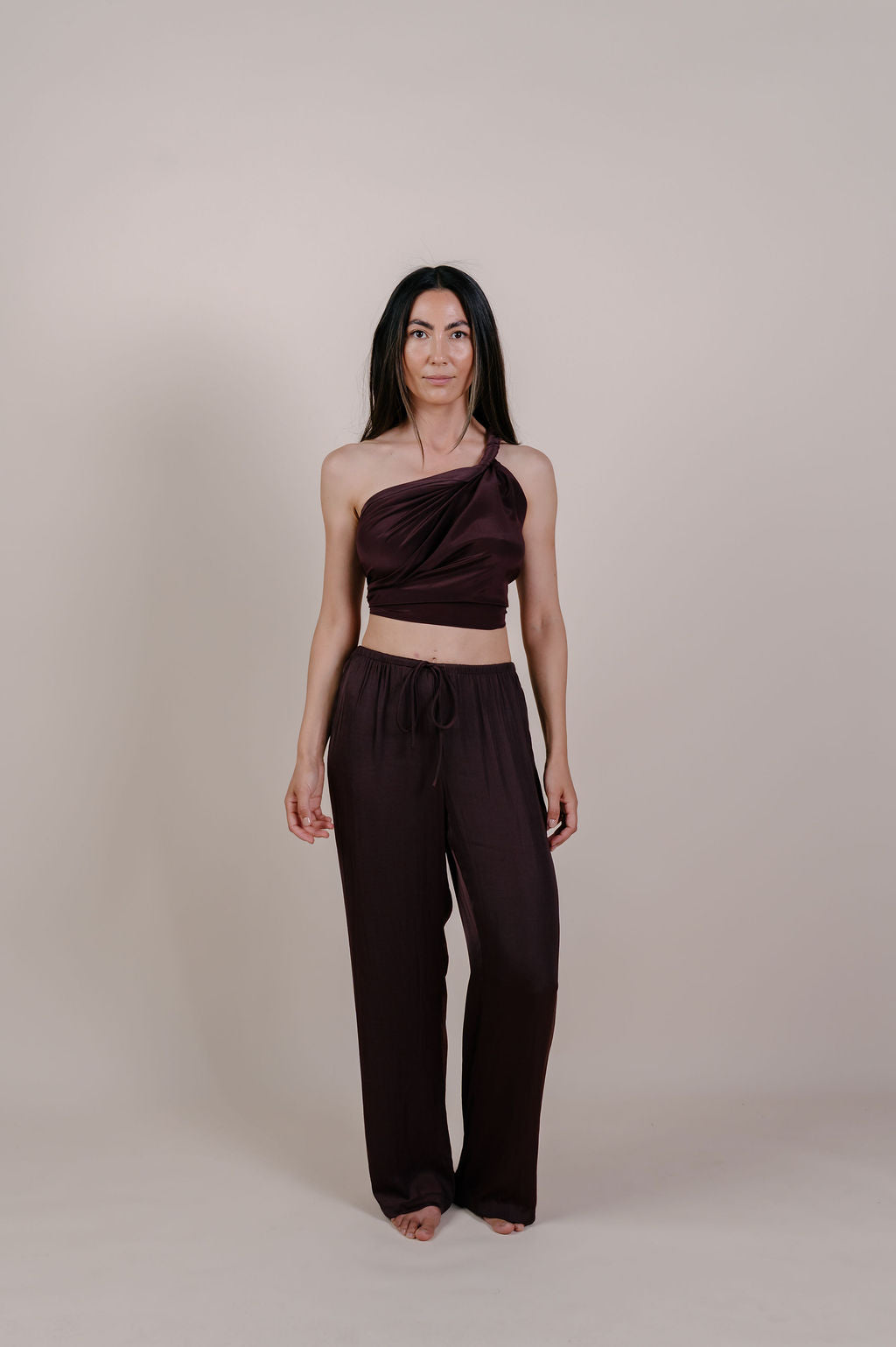 Model wearing the Noa solid chocolate silk pareo by Novo Pareo. 100% Mulberry Silk Twill in deep chocolate brown, minimalist and timeless design for refined Australian resort wear.