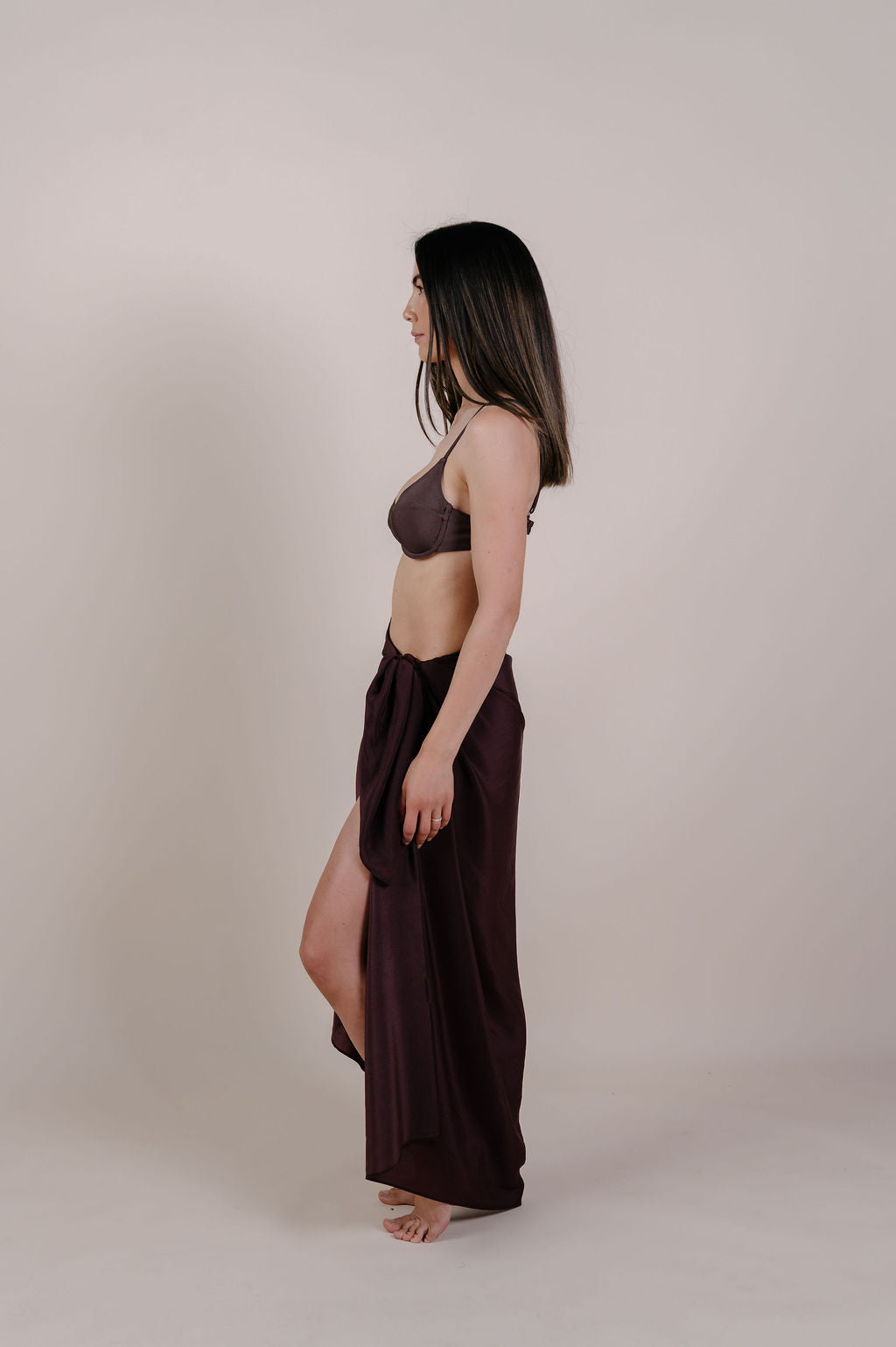 Model wearing the Noa solid chocolate silk pareo by Novo Pareo. 100% Mulberry Silk Twill in deep chocolate brown, minimalist and timeless design for refined Australian resort wear.
