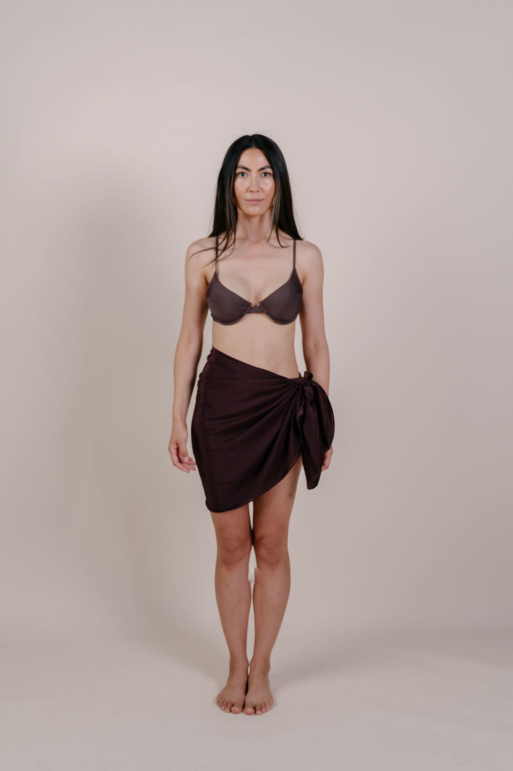Model wearing the Noa solid chocolate silk pareo by Novo Pareo. 100% Mulberry Silk Twill in deep chocolate brown, minimalist and timeless design for refined Australian resort wear.